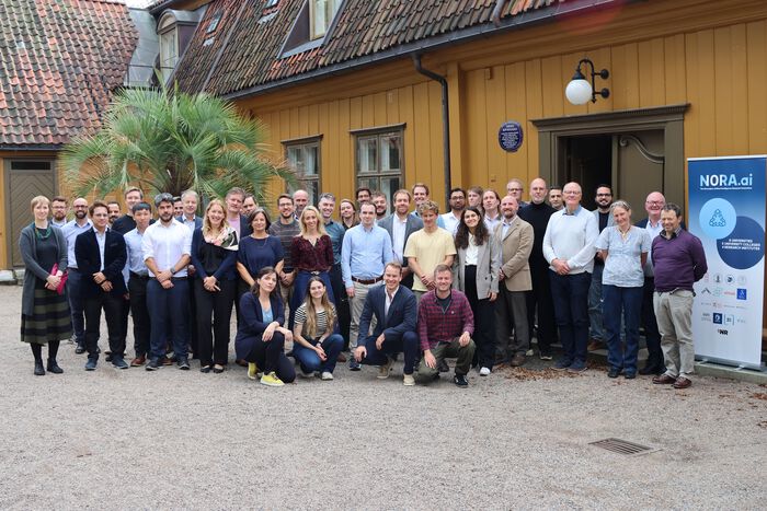 All participants gathered in front of a yellow building.