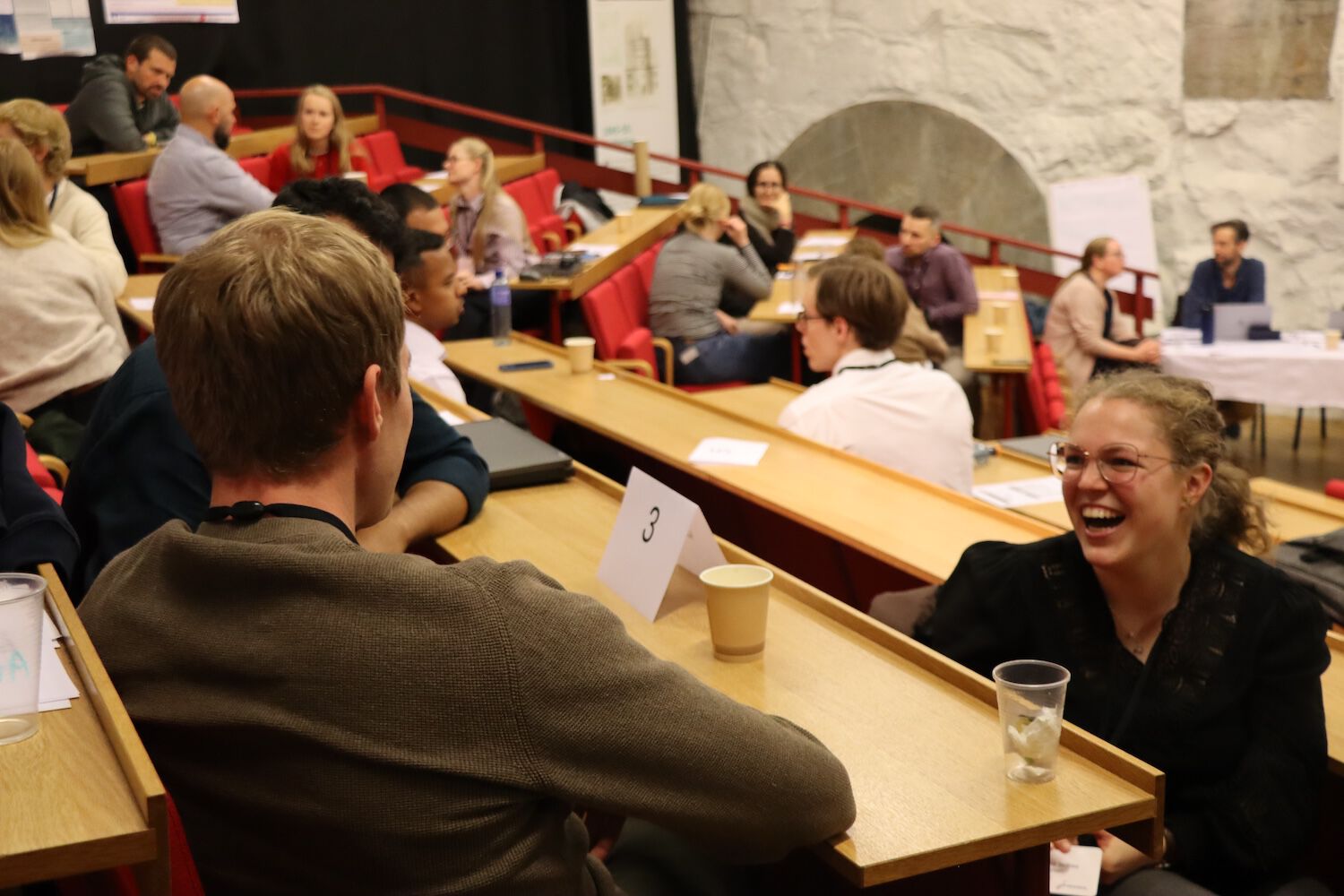 Students talking - one with a happy facial expression turned towards the camera