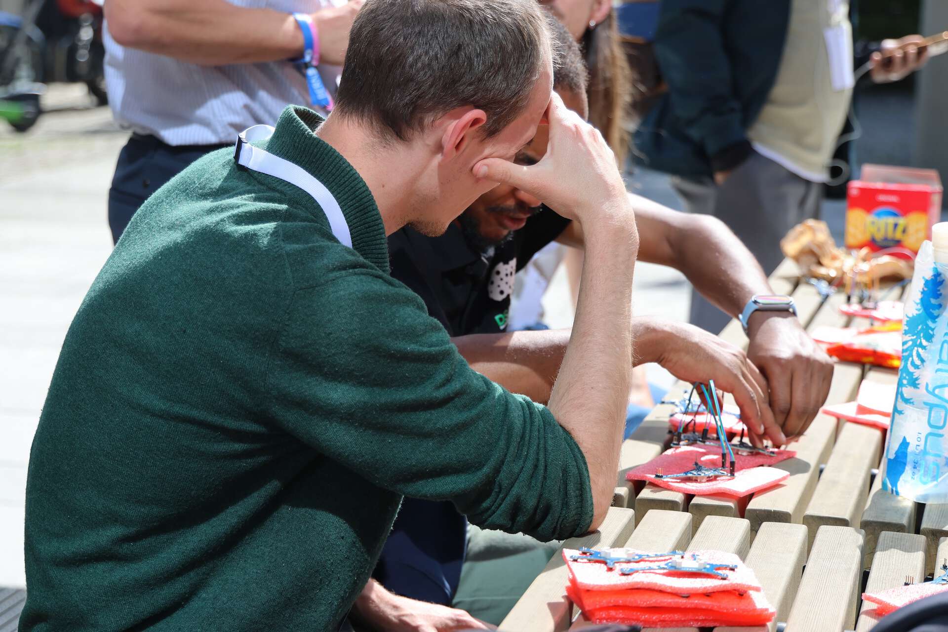 People sitting outside, building something technical