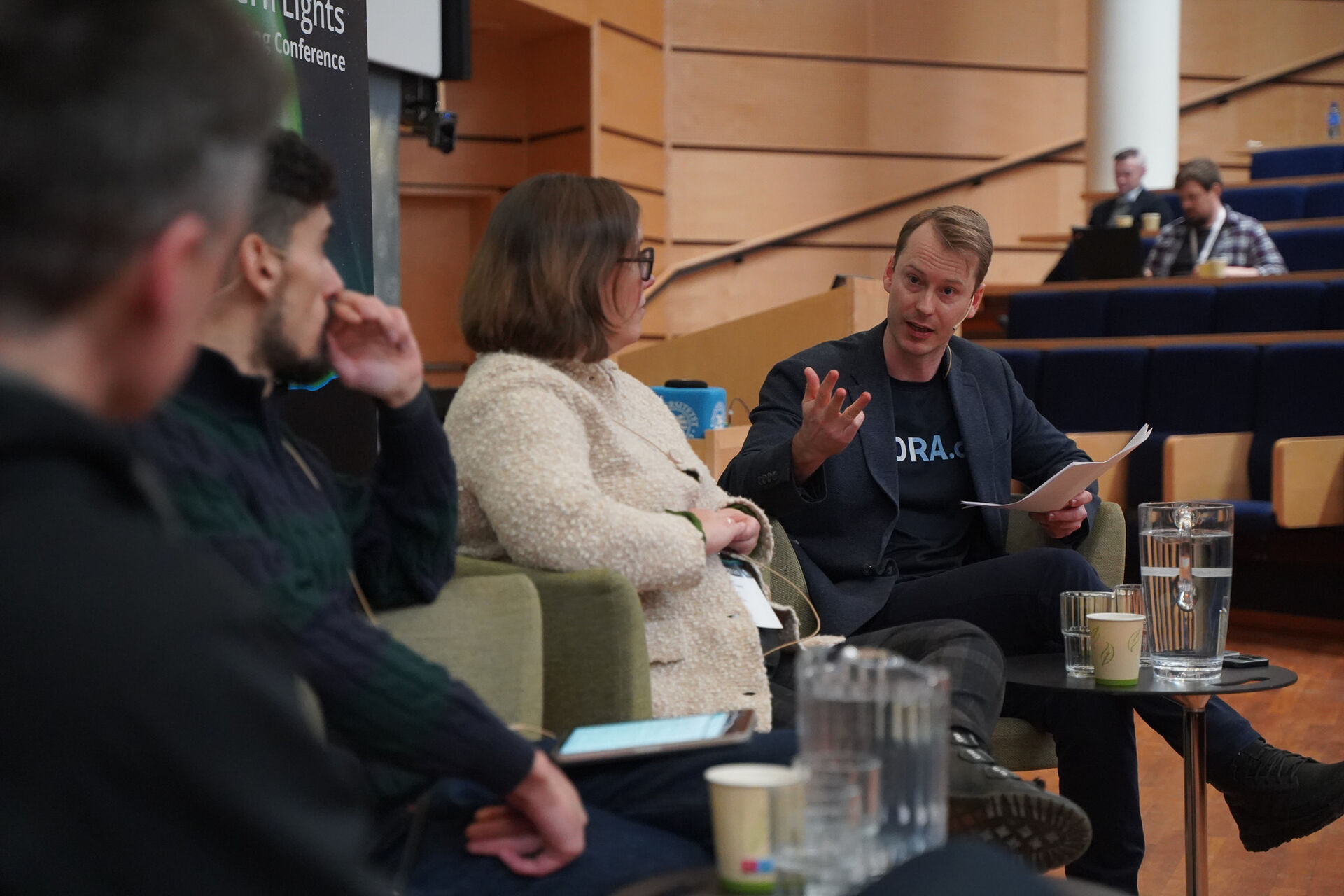 Four people in a panel discussion, one facing the camera