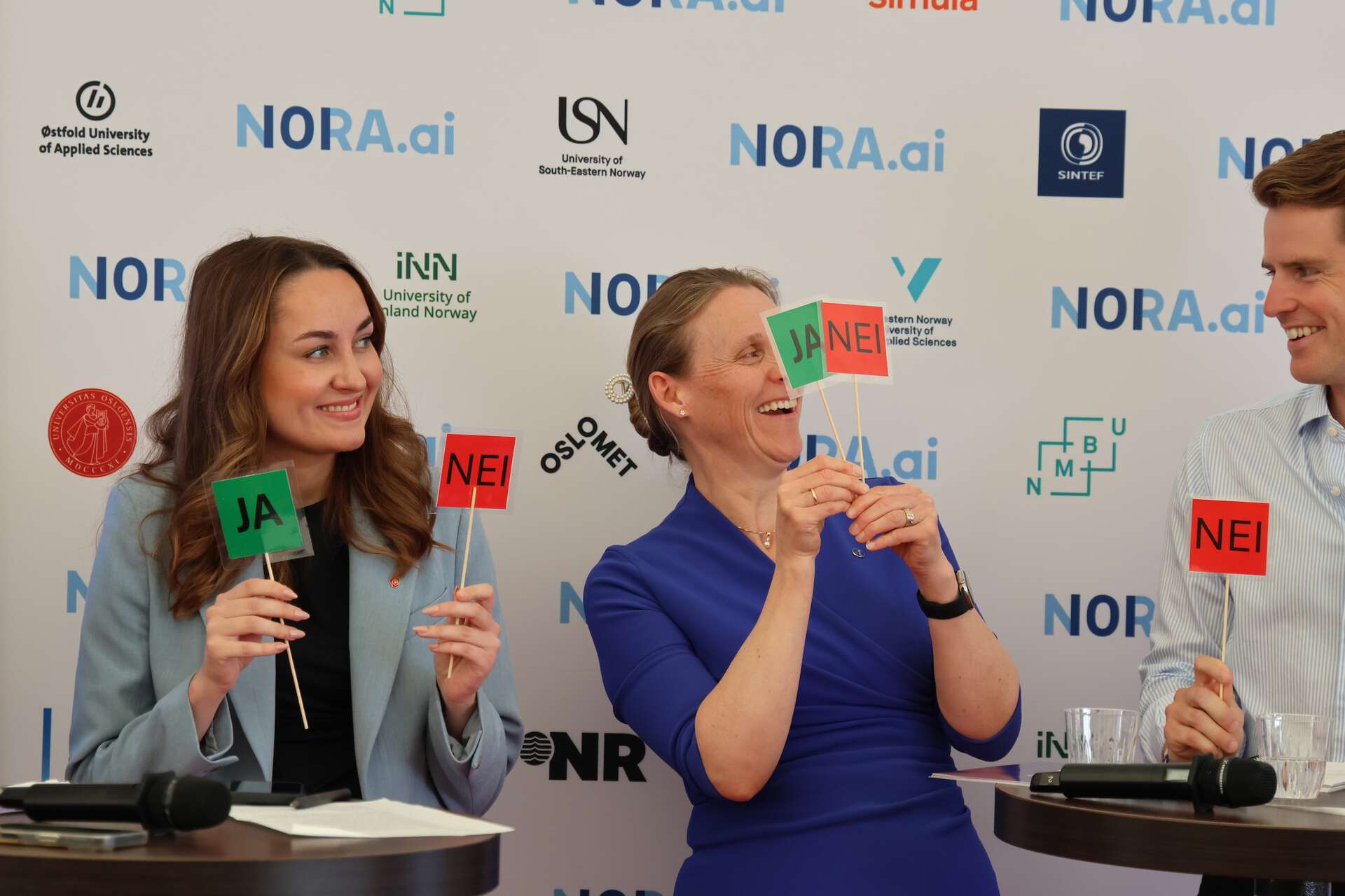 Three people holding up yes and no signs
