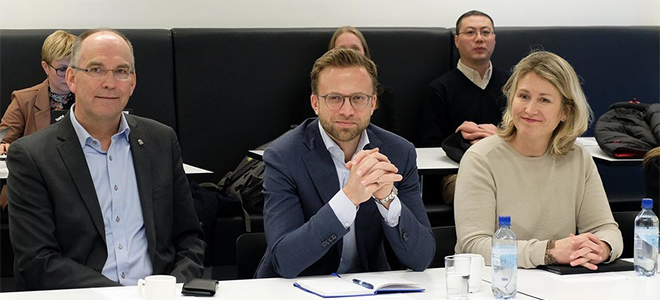 tre personer smiler til kamera