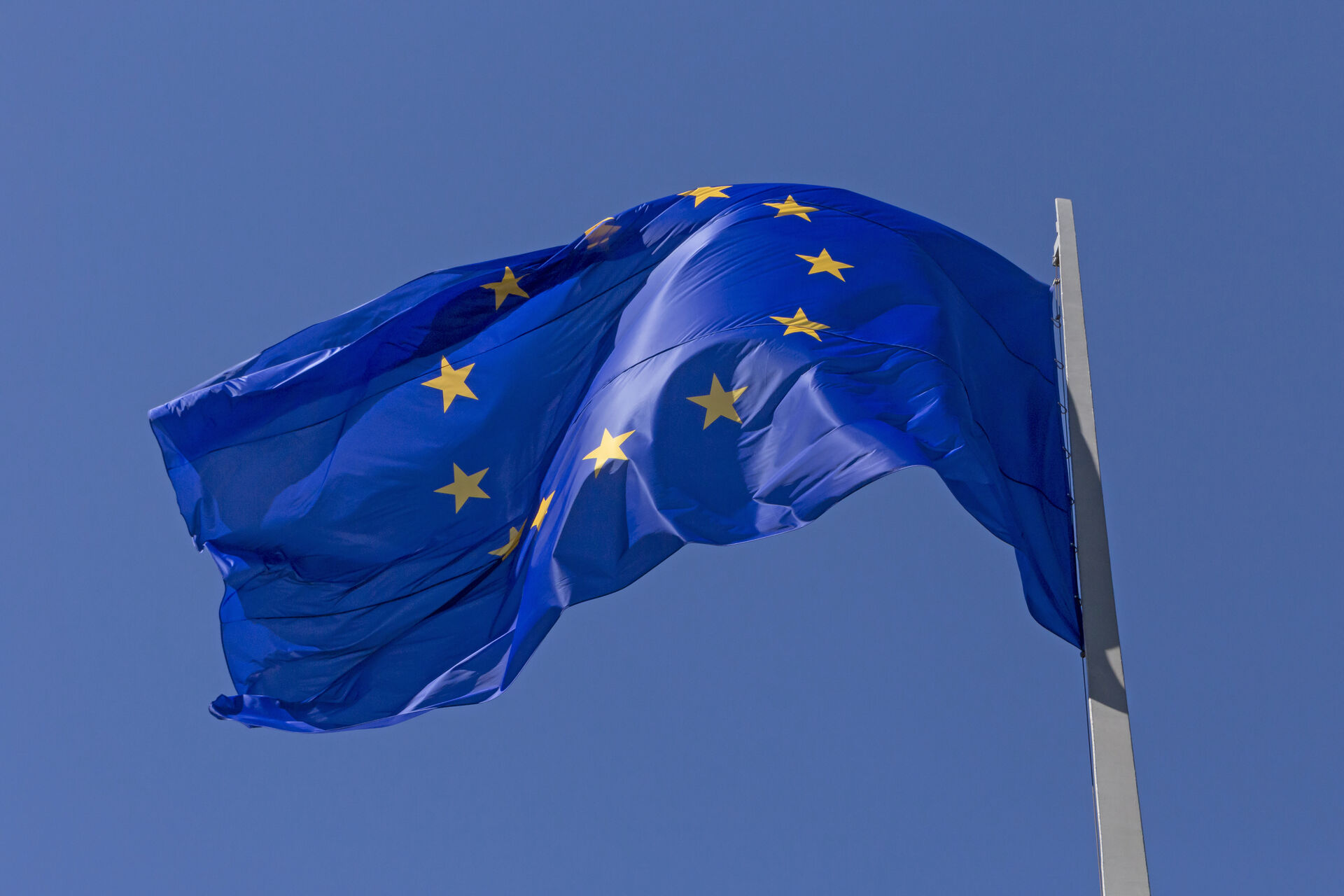 EU flagg som vaier i vinden, blå himmel