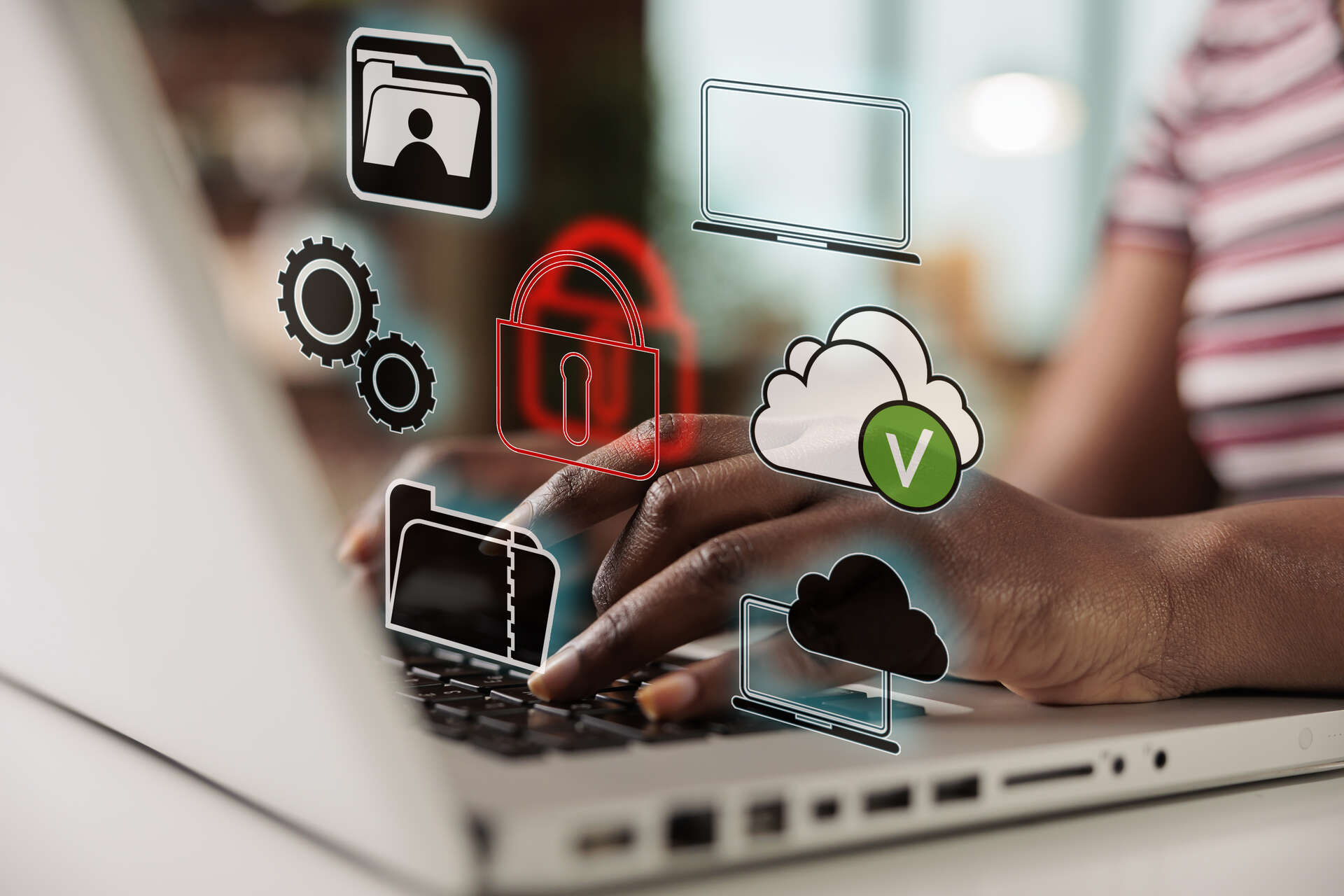 Person typing on a computer, tech symbols like the cloud above the keyboard