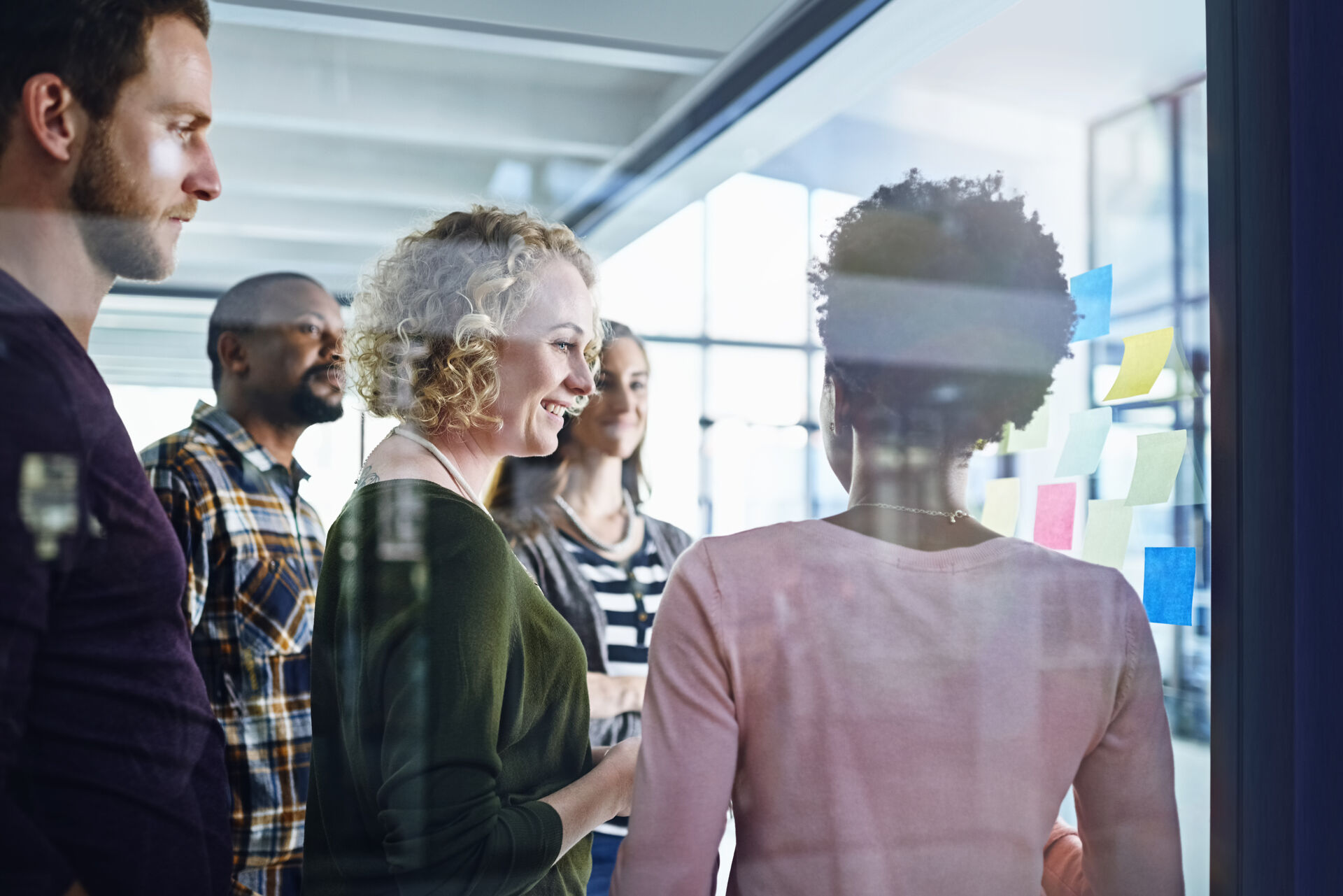 Five different people talking in a meeting room, a diverse group