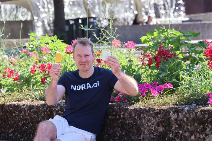 Michael Solvang sitter foran blomster, holder opp to is