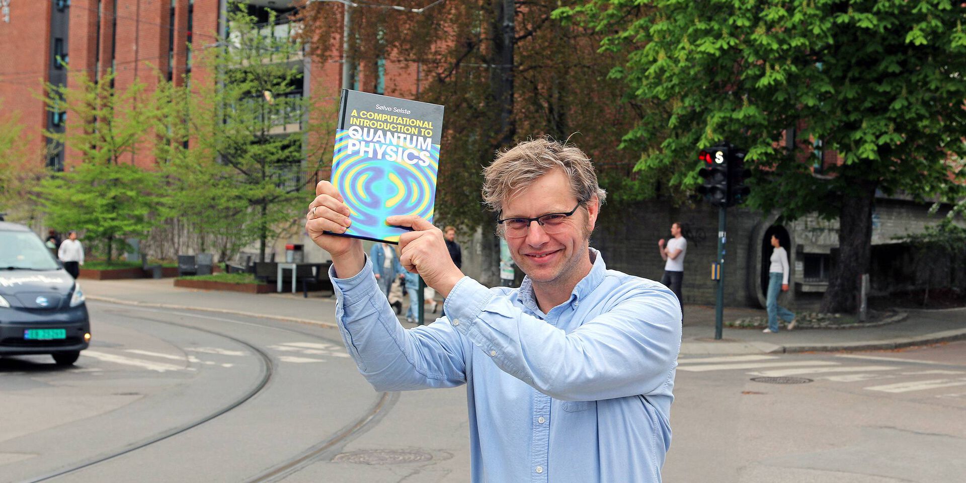 Professor Selstø holder opp boken han har skrevet