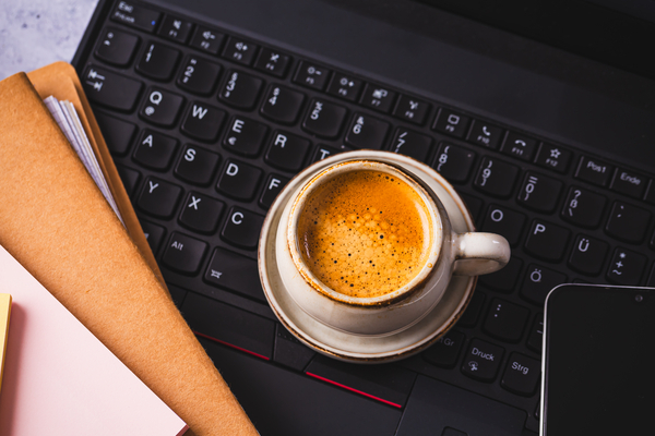 Coffee on keyboard, papers on the side